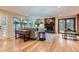 Bright living room featuring hardwood floors, stone fireplace, and views of the backyard and gazebo at 26732 Main St, Conifer, CO 80433