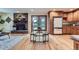 Living room open to kitchen, featuring a stone fireplace, hardwood floors, and access to the backyard at 26732 Main St, Conifer, CO 80433