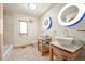 Bright bathroom with double sinks, unique lighting, and tile flooring at 1942 Kentmere Dr, Longmont, CO 80504