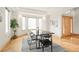 Dining room with large windows, black marble table, decorative wall art, and hardwood floors at 1942 Kentmere Dr, Longmont, CO 80504