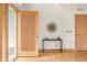 Bright entryway with an open front door, light wood floors, modern table and decorative art at 1942 Kentmere Dr, Longmont, CO 80504