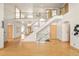 Grand entryway with open staircase, glass railings, hardwood floors, and abundant natural light at 1942 Kentmere Dr, Longmont, CO 80504