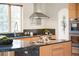 Bright kitchen with granite countertops, stainless steel hood, and modern faucet at 1942 Kentmere Dr, Longmont, CO 80504