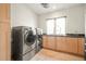 Spacious laundry room with modern appliances, cabinetry, and tile flooring at 1942 Kentmere Dr, Longmont, CO 80504