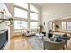 Airy living room boasts high ceilings, a modern fireplace, and expansive windows offering ample natural light at 1942 Kentmere Dr, Longmont, CO 80504