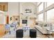 Open-concept living room with high ceilings, fireplace, and lots of natural light from the expansive windows at 1942 Kentmere Dr, Longmont, CO 80504