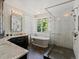 Elegant bathroom featuring a soaking tub, walk-in shower, double vanity, and stylish fixtures at 6405 Warriors Run, Littleton, CO 80125