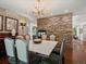 This dining room features a stone wall, hardwood flooring and a modern light fixture at 6405 Warriors Run, Littleton, CO 80125