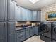 Well-designed laundry room features gray cabinets and modern washer/dryer at 6405 Warriors Run, Littleton, CO 80125