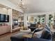 Comfortable living room with a stone fireplace, tv and access to the kitchen at 6405 Warriors Run, Littleton, CO 80125