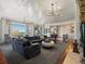 Open concept living room with access to the foyer, stone fireplace and outdoor views at 6405 Warriors Run, Littleton, CO 80125