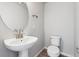 Powder room features pedestal sink, oval mirror, modern fixtures, and tile flooring at 451 Interlocken Blvd # 104, Broomfield, CO 80021