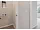 Hallway showing laundry hookups, wood-look floors, and doorway to carpeted room at 451 Interlocken Blvd # 104, Broomfield, CO 80021