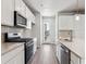 Modern kitchen boasts stainless steel appliances, light countertops, white cabinets, and wood flooring at 451 Interlocken Blvd # 104, Broomfield, CO 80021
