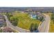 Community aerial shot showcasing ample green space, a swimming pool, and convenient access to a well maintained road at 10240 Travertine Pl, Parker, CO 80134