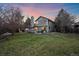 Large back yard with well-kept lawn, mature trees, a patio, and outdoor seating for relaxation and entertaining at 10240 Travertine Pl, Parker, CO 80134