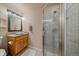 Well-lit bathroom features a glass shower, wooden vanity, and elegant lighting fixture, creating a serene atmosphere at 10240 Travertine Pl, Parker, CO 80134