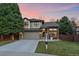 Charming two-story home featuring a brick facade, well-manicured lawn, and a welcoming porch swing at 10240 Travertine Pl, Parker, CO 80134