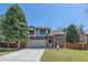 Charming two-story home featuring a brick facade, well-manicured lawn, and a welcoming porch swing at 10240 Travertine Pl, Parker, CO 80134