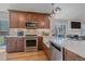 Well-equipped kitchen with stainless steel appliances, wooden cabinets, and stone countertops at 10240 Travertine Pl, Parker, CO 80134