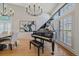 Bright dining room with hardwood floors, elegant chandeliers, grand piano and large windows at 10240 Travertine Pl, Parker, CO 80134