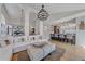 Spacious living room with a view of the kitchen, featuring modern lighting and comfortable seating at 10240 Travertine Pl, Parker, CO 80134