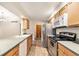Functional kitchen with stainless steel appliances, wood cabinets, and tile flooring at 2043 S Salida St, Aurora, CO 80013