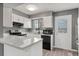 Modern kitchen featuring white cabinetry, granite countertops, and updated appliances at 1671 S Idalia Cir # D, Aurora, CO 80017