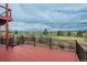 A spacious outdoor deck with black railing offers picturesque views of the sprawling green golf course and the surrounding landscape at 7965 S Eudora Cir, Centennial, CO 80122