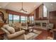 Inviting living room with vaulted ceiling, brick fireplace, large windows providing abundant natural light and scenic views at 7965 S Eudora Cir, Centennial, CO 80122