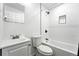 An all-white tiled bathroom featuring a shower and bath, vanity and toilet at 1941 Alton St, Aurora, CO 80010