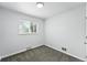 Bright bedroom featuring neutral walls, gray carpet, and a window providing ample natural light at 1941 Alton St, Aurora, CO 80010