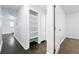 The long hallway has hardwood floors, and shelving, and provides an open view to the adjacent rooms at 1941 Alton St, Aurora, CO 80010