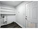Laundry area with white shelving, modern flooring, and access to the exterior at 1941 Alton St, Aurora, CO 80010