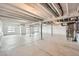 Unfinished basement with white painted ceiling beams, concrete floors, and two windows at 454 Basin Daisy St, Castle Rock, CO 80104