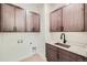 Laundry room featuring dark wood cabinets, white countertops, and a stainless steel sink at 454 Basin Daisy St, Castle Rock, CO 80104