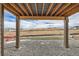 Covered patio with gravel stones overlooking construction and distant homes at 454 Basin Daisy St, Castle Rock, CO 80104