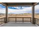 Covered deck with brown wooden railing overlooking construction and distant homes at 454 Basin Daisy St, Castle Rock, CO 80104