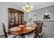 Elegant dining room boasts a dark wood china cabinet, chandelier, and a beautifully set table at 3092 Fox Sedge Pl, Highlands Ranch, CO 80126
