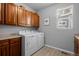Functional laundry room with upper cabinets, countertop space, and modern washer and dryer units at 3092 Fox Sedge Pl, Highlands Ranch, CO 80126