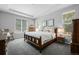 Spacious primary bedroom with tray ceiling, large windows, and carpeted floor; two matching bedside tables at 3092 Fox Sedge Pl, Highlands Ranch, CO 80126