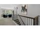 Stairway landing showcasing a painting and overlooking the open-concept living room with ample light at 3092 Fox Sedge Pl, Highlands Ranch, CO 80126