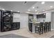 Stylish wet bar with seating, white counters, wine rack, and stainless-steel appliances at 3092 Fox Sedge Pl, Highlands Ranch, CO 80126