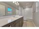 Bathroom with quartz counters, dark cabinets, and tile tub and shower surround at 15902 Stringhalt Way, Parker, CO 80134