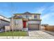 Charming two-story home features a red door, a well-manicured lawn and a two car garage at 15902 Stringhalt Way, Parker, CO 80134