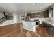 Modern kitchen with stainless steel appliances, island with seating and access to stairs and living area at 15902 Stringhalt Way, Parker, CO 80134