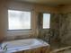 Bright bathroom features soaking tub with tile surround and large walk-in shower with glass door at 1660 Moveen Hts, Monument, CO 80132
