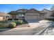 Home exterior featuring a well-maintained lawn, stone accents, and a three-car garage at 1660 Moveen Hts, Monument, CO 80132