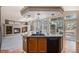Kitchen island with granite countertops, sink, and black dishwasher connects to the living room with fireplace at 1660 Moveen Hts, Monument, CO 80132