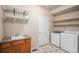 Functional laundry room with modern washer and dryer, sink, storage cabinets, and tile flooring at 1660 Moveen Hts, Monument, CO 80132
